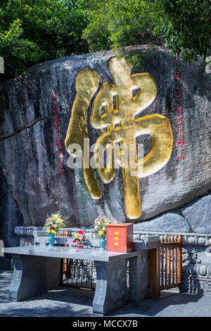 Un alter nella parte anteriore di una scultura in pietra incisa e golden carattere cinese, Tempio Nanputuo (South Putuo), Xiamen, Cina Foto Stock
