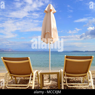 Sedie a sdraio sulla spiaggia di Ipsos a Corfu Foto Stock