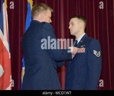 Stati Uniti Air Force Col. Lancia Schmidt, 752nd Special Operations Group commander, presenta il personale Sgt. Joshua chiamata, sessantasettesima Special Operations Squadron MC-130J Commando II loadmaster, con illustri battenti croce con Valor a RAF Mildenhall, Inghilterra, 8 febbraio 2018. Due Air Commandos ha ricevuto il Distinguished Flying Cross con coraggio per il loro eroismo durante un rifornimento di aria durante la caduta sotto il fuoco nemico nella provincia di Helmand, Afghanistan, 5 gennaio 2016. (U.S. Air Force foto di Senior Airman Alexandra Ovest) Foto Stock