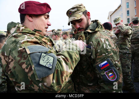 Un esercito sloveno perni soldato esperto Badge Fante (BEI) su un altro esercito sloveno soldato durante l'esperto Fantassin Badge (BEI) cerimonia alla Caserma del Din, Vicenza, Italia, 15 febbraio 2018. (U.S. Esercito foto di Paolo Bovo) Foto Stock