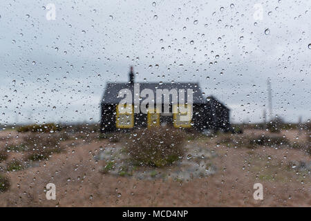 Prospettiva Cottage, Dungeness, Derek Jarman dell ex casa con il suo famoso giardino creato da una spiaggia di ciottoli. Prese durante la pioggia dalla mia finestra auto. Foto Stock