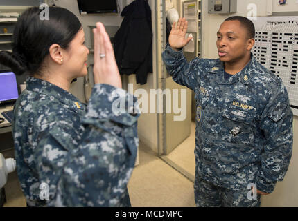 NORFOLK, Virginia (feb. 21, 2018) -- Capo specialista del personale Jerry Eunice, da Jacksonville, Florida, assegnato alla USS Gerald Ford (CVN 78) dipartimento amministrazione, recita il giuramento di arruolamento data dalla Ensign Kristine Gavino, Ford personale del funzionario, durante la sua cerimonia reenlistment. (U.S. Foto di Marina di Massa lo specialista di comunicazione di terza classe Connor D. Loessin) Foto Stock