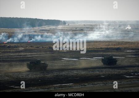 Stati Uniti Stryker veicoli tattici in anticipo tramite l'obiettivo durante la fase di esercizio Puma Live esercitazione antincendio vicino Bemowo Piskie Area Formazione, Polonia nel febbraio 23, 2018. Gruppo di combattimento della Polonia è un luogo unico e multinazionali del Battle Group, composta di Stati Uniti, Regno Unito, croato e soldati rumeni che servono con il polacco della XV Brigata meccanizzata come una forza di dissuasione nel nord-est della Polonia a sostegno della NATO in avanti rafforzata presenza. (U.S. Foto dell'esercito da Capt. Gary Loten-Beckford/ 22 Mobile degli affari pubblici distacco) Foto Stock