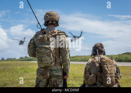 Il Mag. Sean Conley, 36th mobilità squadrone di risposta direttore del personale, a sinistra e lo Staff Sgt. Adam Radamacher, 736th delle forze di sicurezza Squadron Fly Away Security Team di piombo, guardare la U.S. Navy MH-60S elicotteri assegnati ad un elicottero di combattimento di mare Squadron 25, decollo dopo il rifornimento di carburante utilizzando un elicottero conveniente sistema di rifornimento durante l'esercizio a far fronte nord 2018 a Tinian, U.S. Repubblica della Mariana Islands settentrionale, Feb. 26. Esercizio di far fronte nord è una lunga tradizione di esercizio progettata per migliorare aria multilaterale di operazioni tra Stati Uniti Air Force, U.S. Navy, U.S. Marine Corps, Japan Air Self-Defens Foto Stock