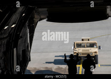 Stati Uniti Avieri dal ventiduesimo Airlift Squadron di guida di un Humvee su un C-5M Super Galaxy aeromobile durante un Tuskegee patrimonio aviatori volo a Ramstein Air Base, Germania, 28 febbraio, 2018. Un tutto nero C-5M equipaggio condotto la missione che visualizzate orgoglio nel loro patrimonio e hanno mostrato la loro capacità di condurre una rapida mobilità globale oggi in forza dell'aria mediante erogazione di U.S. Gli elicotteri dell esercito in Afghanistan. (U.S. Air Force foto di Master Sgt. Joey Swafford) Foto Stock