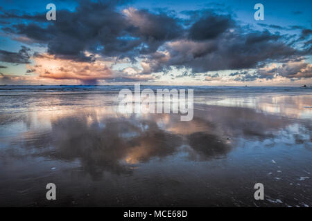 Nuvole temporalesche cancellazione al tramonto sulla spiaggia di cannone, Oregon Foto Stock