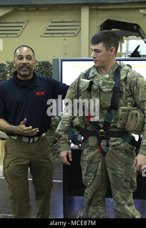 CAMP BUEHRING, Kuwait - 1° SFAB soldato riceve adeguate istruzioni su come sfruttare un tiratore sulla cintura da Jimmy Lindsey, istruttore tecnico per il rollover Egress miniera agguato resistente protezione (MRAP) simulatore di addestramento 22 Febbraio, 2018. Il SFAB è una unità specializzata di Fort Benning, Ga. distribuzione in Afghanistan per consigliare e assistere la nazionale afghano di difesa delle forze di sicurezza. (U.S. Foto dell'esercito dal sig. Brent Thacker) Foto Stock