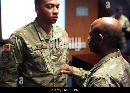 Stati Uniti Comando Esercito Sgt. Il Mag. Gregorio Rowland, 2a teatro vigili del segnale senior leader arruolato, perni primo sergente rank su Master Sgt. Corrie Moore, designato primo sergente per la sede centrale e sede società, 2° segnale Teatro Bde., Aprile 13, 2018 in Wiesbaden, Germania. (U.S. Foto dell'esercito da William B. King) Foto Stock