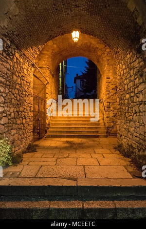 Ingresso ad arco con muri in pietra e la vecchia città di Ioannina di notte, Grecia Foto Stock