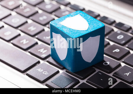 Close-up di scudo per la sicurezza i simboli sul blocco blu sopra la tastiera del notebook Foto Stock
