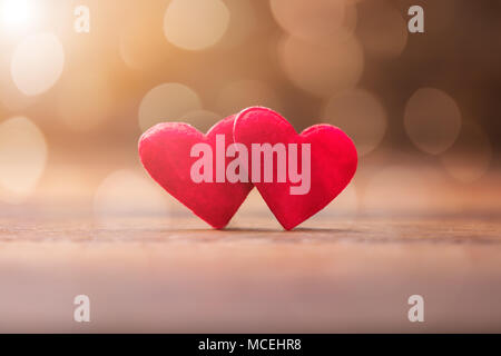 Ancora la vita di due Red Valentino cuore sulla scrivania in legno Foto Stock