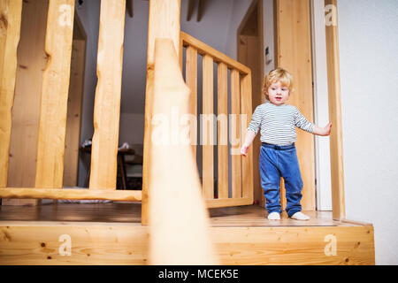 Il Toddler boy in situazione di pericolo a casa. Bambino il concetto di sicurezza. Foto Stock