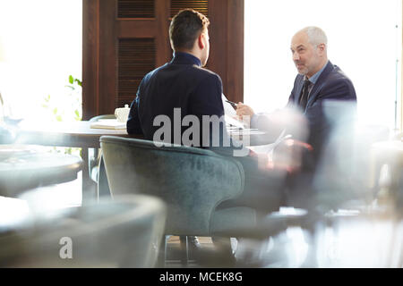 Coppia grey-haired imprenditore caucasico a discutere di un nuovo progetto con il suo partner commerciale in ristorante Foto Stock