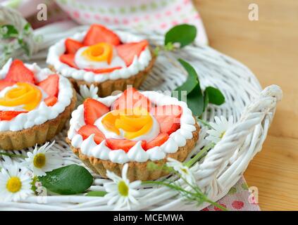 Piccolo a forma di cesto crostata con pesche e fragole con panna Foto Stock