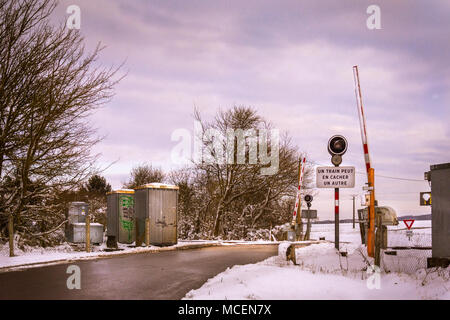 Incrocio ferroviario in Normandia in inverno con la neve Foto Stock
