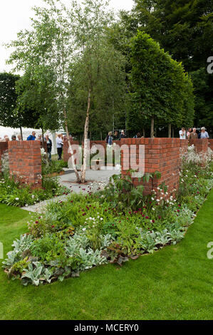 Vista persone pleached alberi e la fioritura delle piante di confine attraverso intercapedini nelle pareti in "l'Albert Dock Garden' - RHS Flower Show, Tatton Park, England, Regno Unito Foto Stock