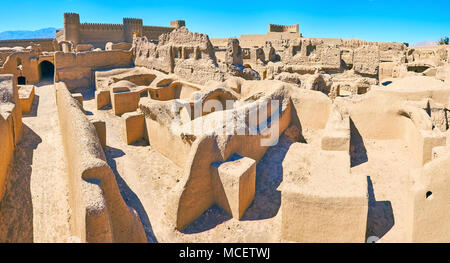 Panorama sui tetti di antico rovinato quartieri residenziali di Arg-e Rayen fortezza con torreggiante castello sullo sfondo, l'Iran. Foto Stock