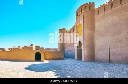 La parete di facciata del castello di Rayen con gate, osservando la terrazza e le rovine di antichi edifici residenziali di fronte ad esso, l'Iran. Foto Stock