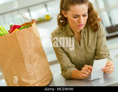 In questione casalinga controllo bill dopo lo shopping in cucina Foto Stock