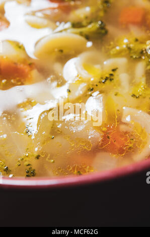 Vicino di casa fatta chunky vegetali e la zuppa di pasta iin tonalità calde dorate. Foto Stock