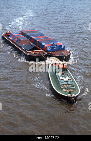 Rimorchiatore tirando due chiatte sul fiume Tamigi, Londra, Inghilterra, 1976 Foto Stock