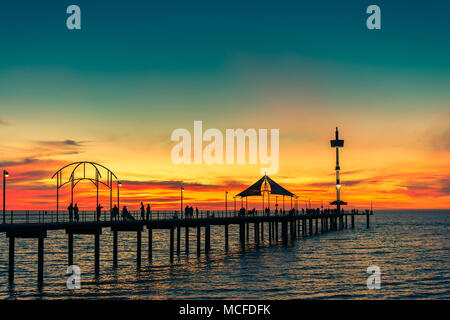 La gente camminare lungo il molo di Brighton al tramonto di sera d'estate Foto Stock