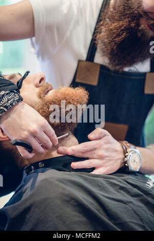 Close-up della mano di un barbiere con le forbici durante la rifinitura Foto Stock