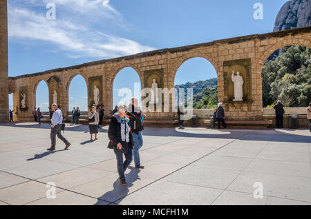 Un muro di pietra a Santa Maria de Montserrat Abbey in Spagna con gli archi e le sculture raffiguranti figure religiose o scene. Foto Stock