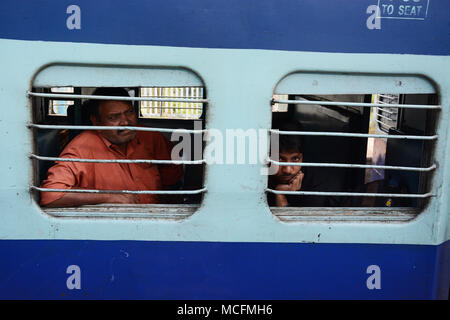 Un uomo e un ragazzo adolescente che viaggiano su un treno in India Foto Stock