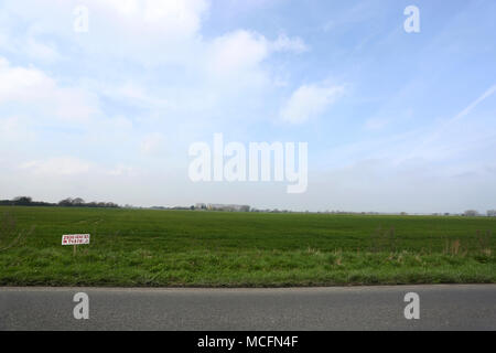 Un bellissimo campo verde con un cartello che diceva "2500 case in questo campo" come la pianificazione è stata concessa per le nuove abitazioni su questo sito, Pagham, West Sussex. Foto Stock