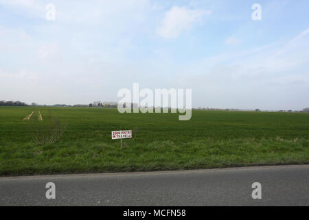 Un bellissimo campo verde con un cartello che diceva "2500 case in questo campo" come la pianificazione è stata concessa per le nuove abitazioni su questo sito, Pagham, West Sussex. Foto Stock