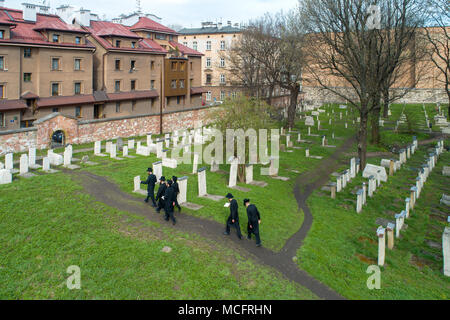 Cracovia in Polonia - 11 Aprile 2018: un gruppo di ebrei ortodossi in nero visitando il cimitero Remuh a ancora attivo Remah sinagoga nel vecchio storico ebraico Ka Foto Stock