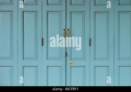 Antique golden porte bloccate su blu porta vecchia sfondo. Foto Stock