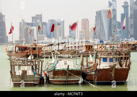 DOHA, Qatar - 15 Aprile 2018: Piccoli pescherecci battenti bandiere Qatar nel porto di torri dietro. Mostra di lealtà sono aumentati a partire dal Qatar w Foto Stock