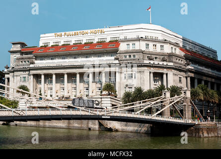 Cavenagh sospensione ponte sopra il Fiume Singapore e Fullerton hotel in background. Foto Stock