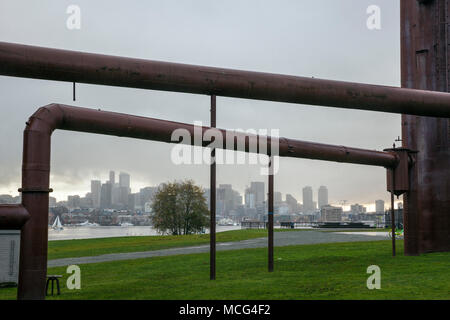 WA14367-00...WASHINGTON - Seattle skyline della città incorniciata dai tubi industriali a gas Parco di opere in un giorno di pioggia. Foto Stock