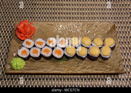 Due tipi di sushi tradizionale Giapponese rotoli futomaki su una rettangolare piastra stilizzata closeup Foto Stock