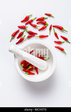 White mortaio e pestello con peperoncino rosso in orientamento verticale con una stanza per il testo Foto Stock