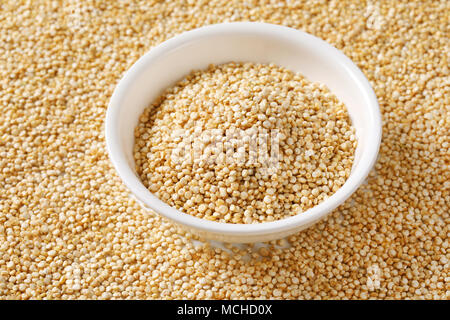 Tazza di quinoa bianco sul semi di quinoa sfondo Foto Stock