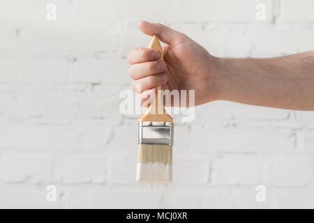 Immagine ritagliata dell uomo con spazzola in vernice bianca Foto Stock