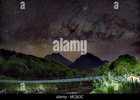 Via lattea in salita sulla cima Monte Kinabalu e Monte Nungkok. Esposizione lunga e alta immagine ISO. Grana visibile e rumore, soft focus e la sfocatura in movimento Foto Stock