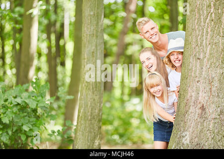 La famiglia felice e i bambini di giocare a nascondino in campagna Foto Stock