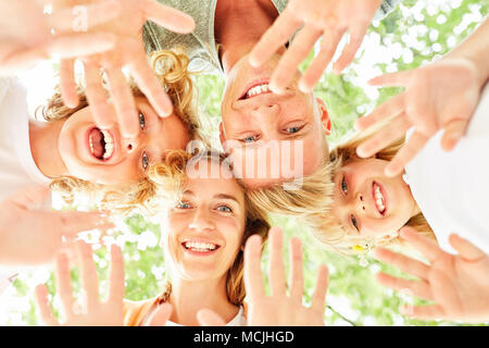 La famiglia e i bambini sono in piedi in cerchio e agitando felicemente Foto Stock