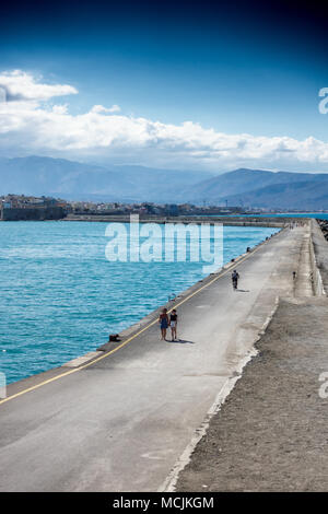 Lungo pontile sul mare con la montagna in background, Heraklion, Grecia Foto Stock