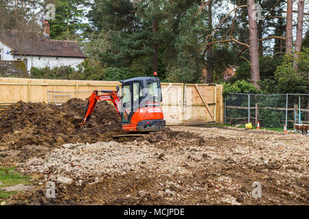 Orange Hitachi impianto pesante escavatore meccanico su un sito di costruzione di costruire una nuova casa su un materiale di riempimento o infill trama nel Surrey, Inghilterra sudorientale, REGNO UNITO Foto Stock