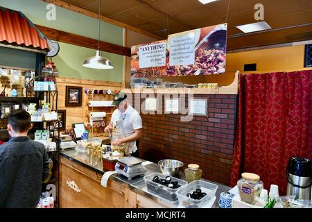 Dipendente di spezie di riempimento di bottiglie in un custom blend spice store in Rehoboth Beach, Delaware, STATI UNITI D'AMERICA Foto Stock