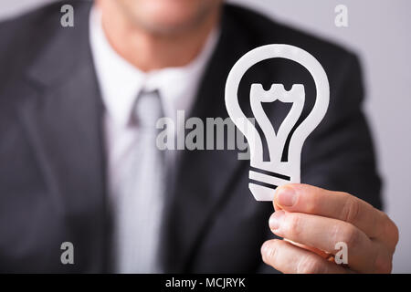 Close-up di un imprenditore di mano azienda lampadina bianco Foto Stock