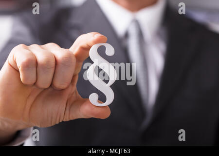 Close-up di un imprenditore la mano che regge il paragrafo simbolo Foto Stock