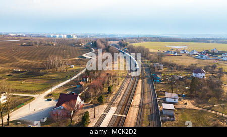 Vista prospettica dall'alto sulle linee ferroviarie. In treno in campagna. vista aerea della stazione ferroviaria. Treno che passa ad una distanza a doppia linea railwa Foto Stock