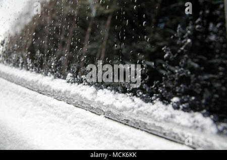 Congelati auto coperti di neve e ghiaccio in inverno. ghiaccio fondente sul vetro dell'auto. close up Foto Stock